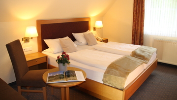 Gedecktes Bett aus einem der Buchbaren Hotelzimmer.