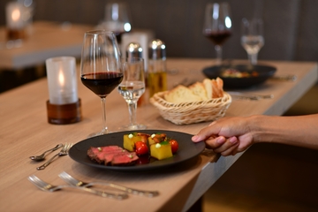 Bild eines servierten Menüs aus der Speisekarte mit Fleisch und Wein.