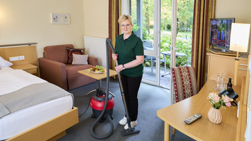 Reinigungskraft beim reinigen eines der Zimmer.