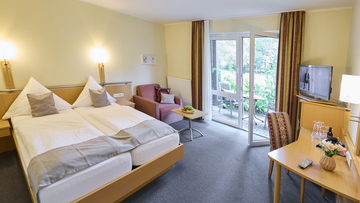 Großes Hotelzimmer mit eigener kleinen Terrasse.
